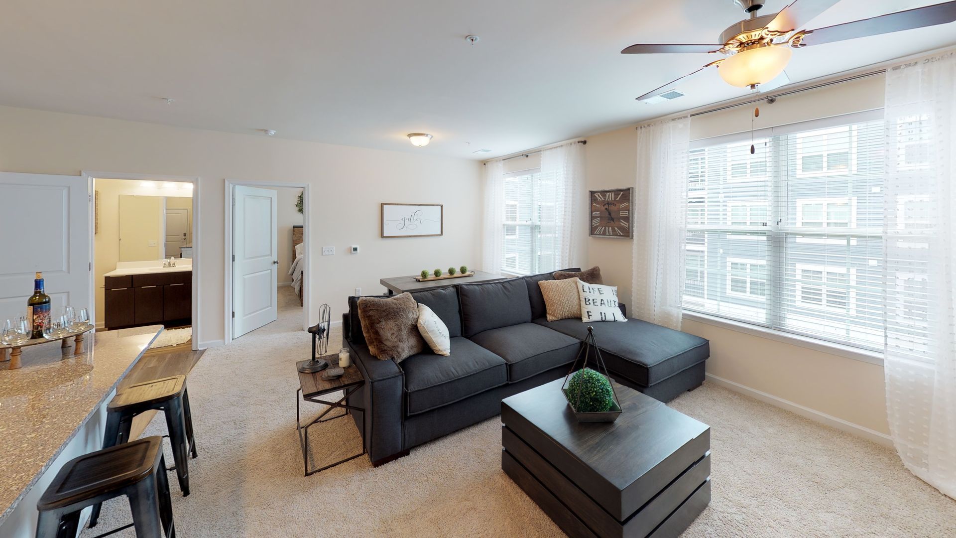 A living room with a couch , coffee table , and ceiling fan.