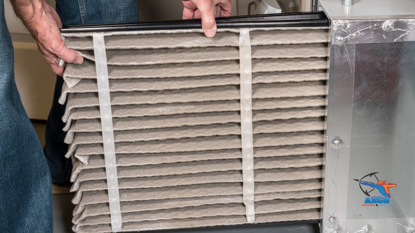 A person is holding a dirty air filter in their hands.