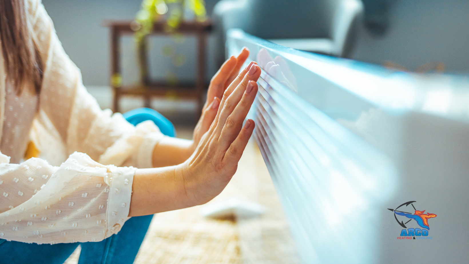 A woman is sitting on the floor in front of an heating unit.