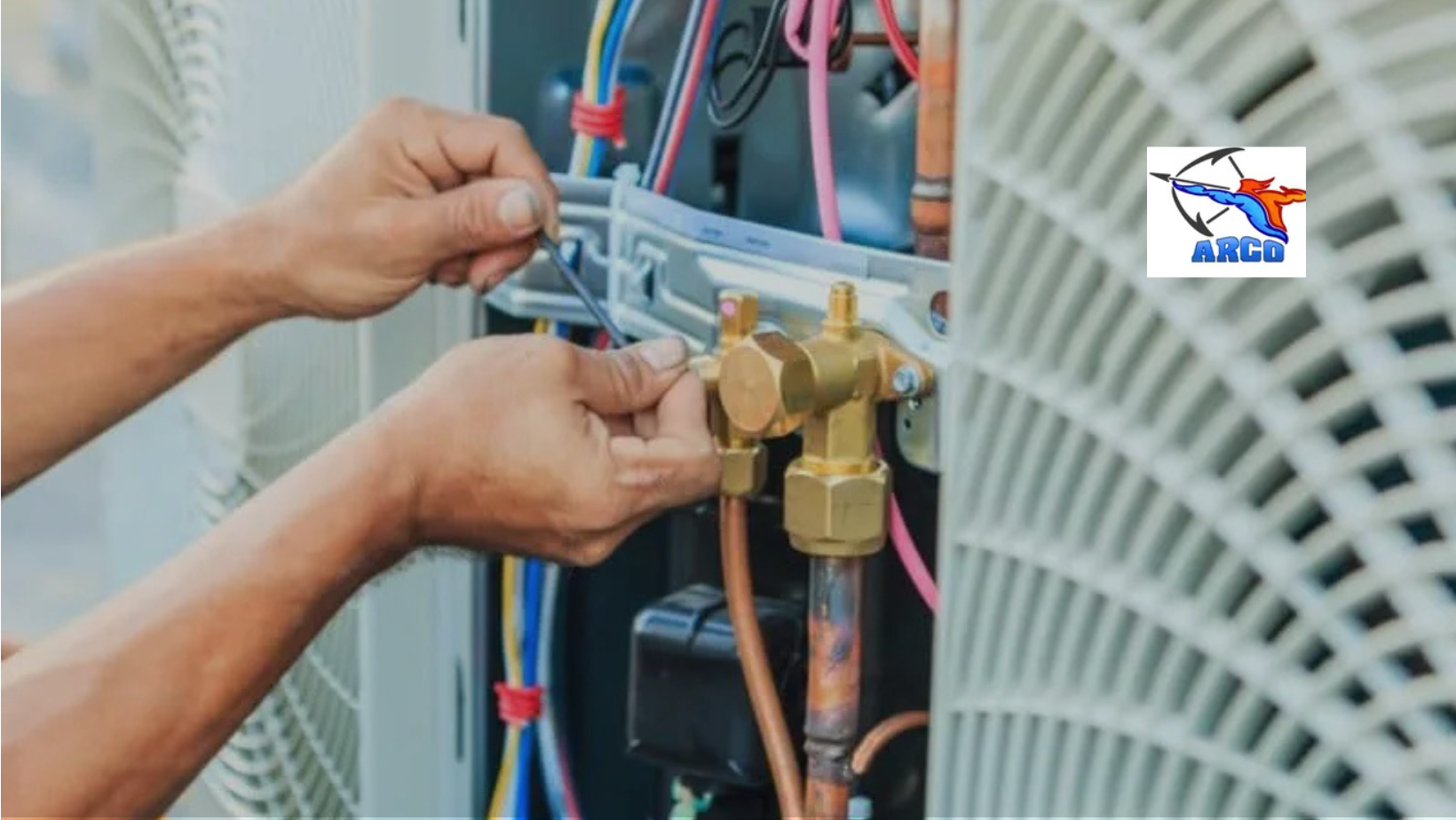 Person's hands working on HVAC system's valve with wiring visible, likely for repair.  Close-up with an ARCO logo.