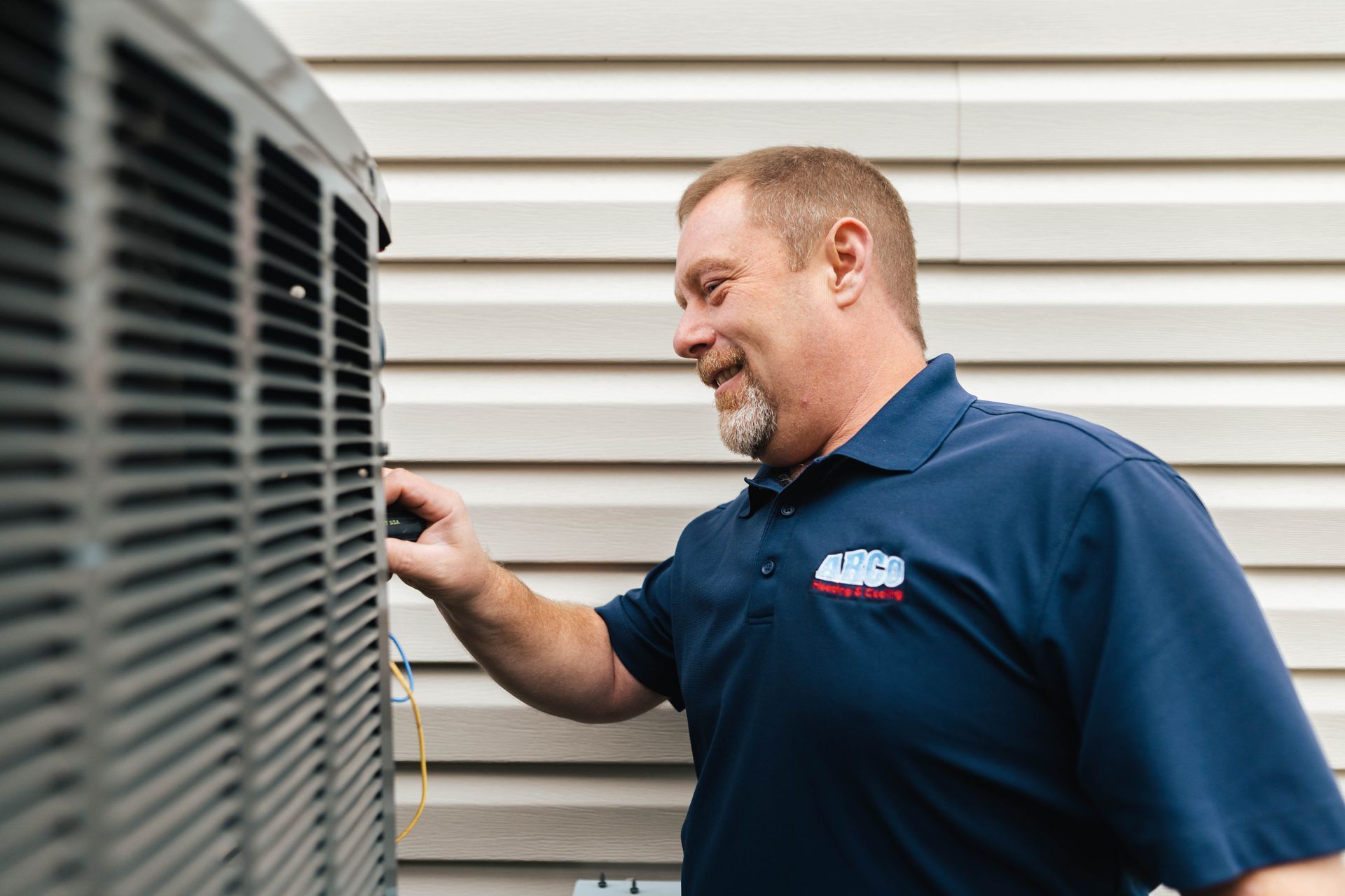 A man diagnosing an outside air conditioner