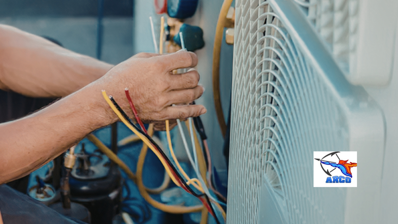 Hands working with colorful electrical wires inside an open appliance cabinet.