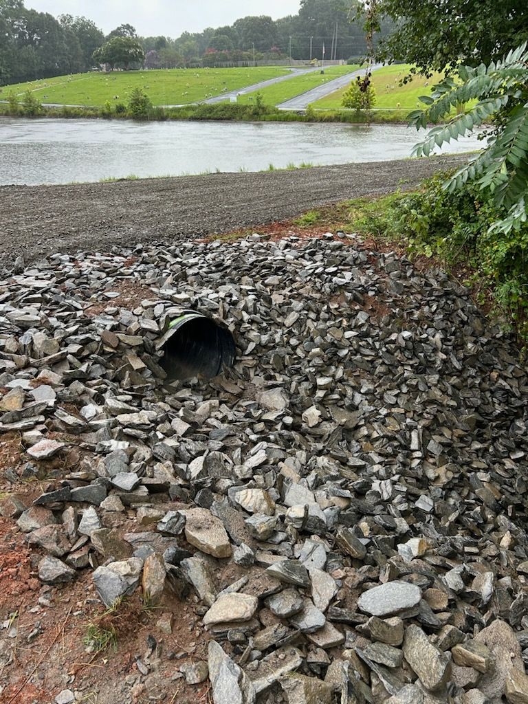 A large pile of rocks with a pipe in the middle of it.