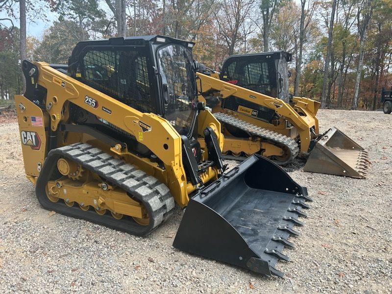 Two bulldozers are parked next to each other in a gravel lot.
