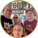 A family posing for a picture in front of a route 66 sign