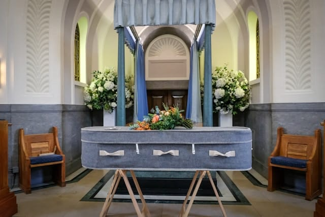 A coffin is sitting on a wooden stand in a church