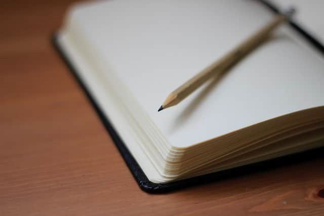 A pencil is sitting on top of an open notebook