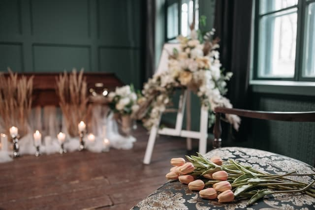 A bunch of flowers are sitting on a chair in a room with candles.