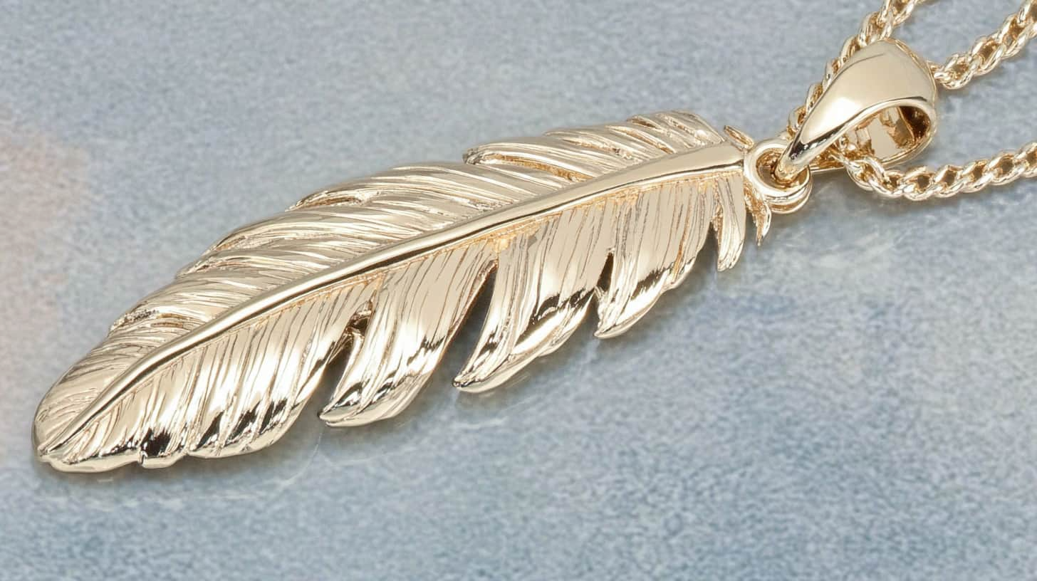 A close up of a gold feather pendant on a chain