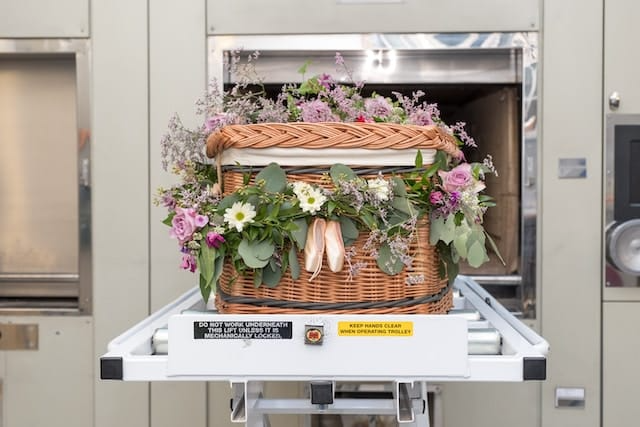 A wicker basket filled with flowers is sitting on top of a conveyor belt.