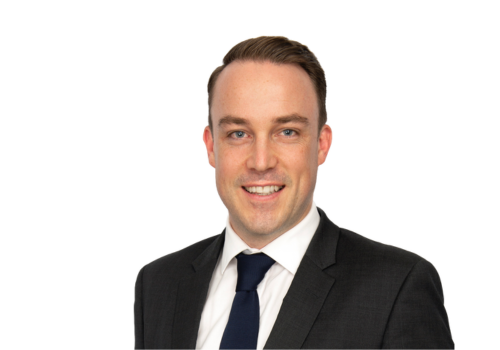 A man in a suit and tie is smiling for the camera.