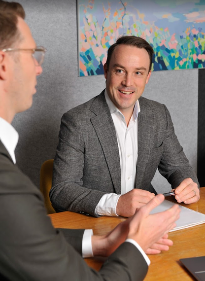 A man in a suit and tie is smiling for the camera.