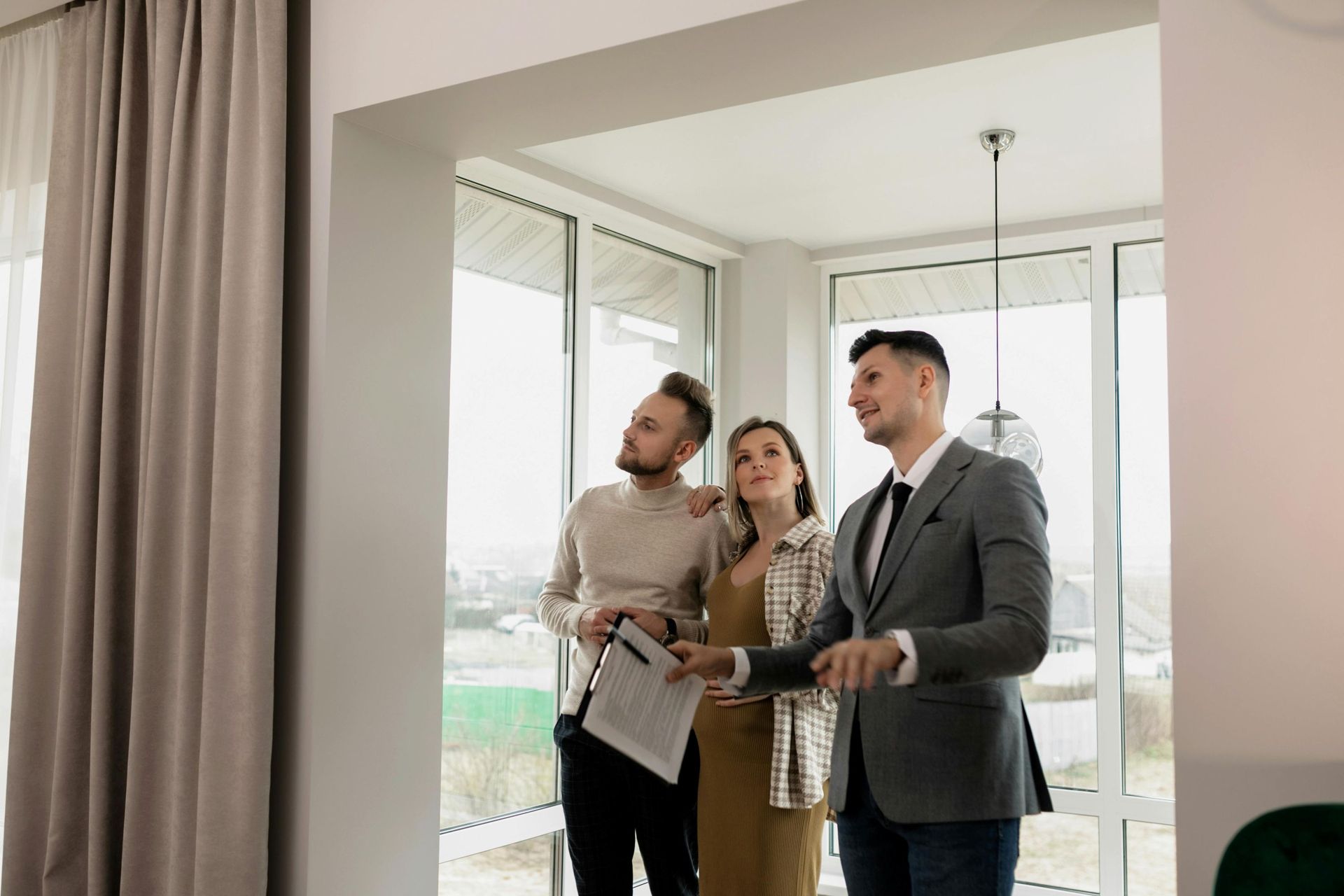couple talking with male realtor inside house