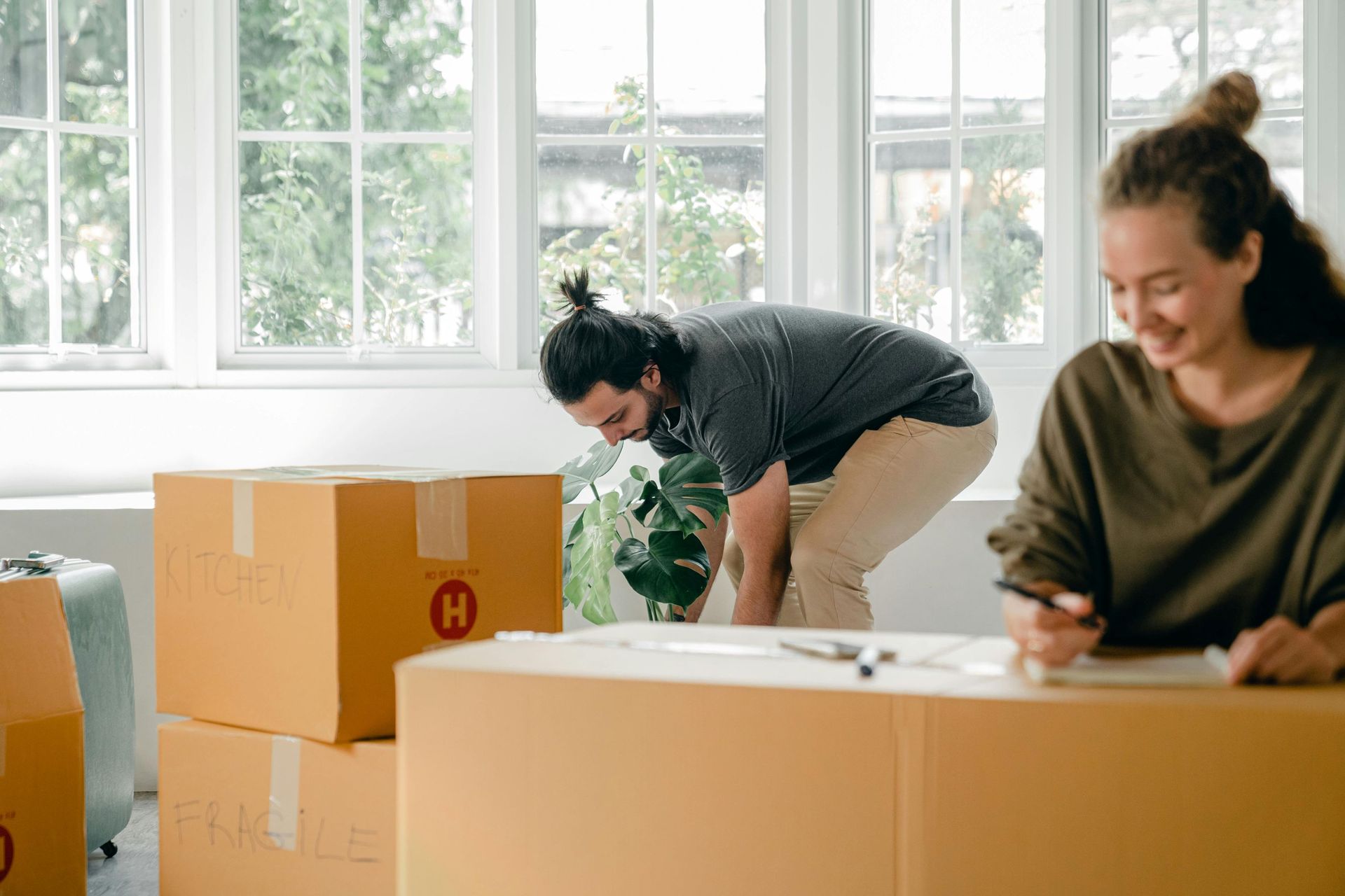 A happy young couple surrounding by boxes at a new home.