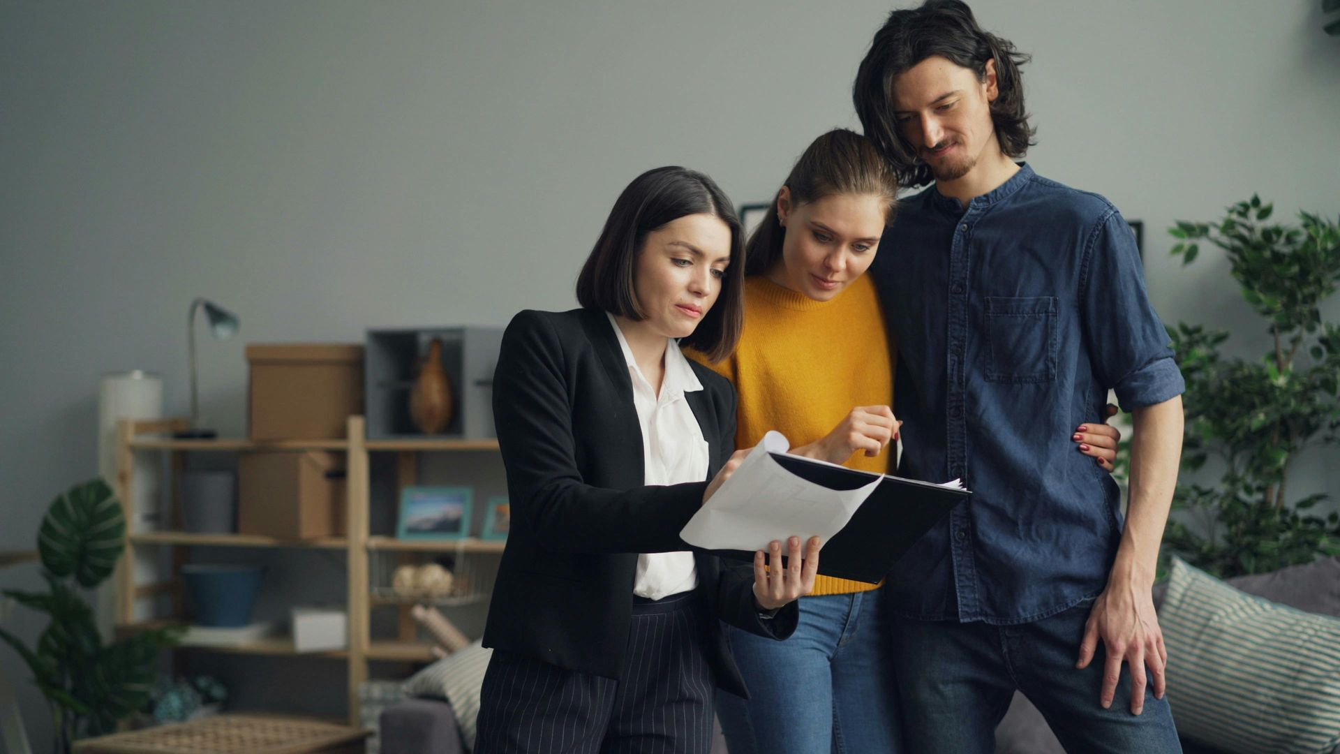 Three coworkers reviewing documents together in a modern office lounge
