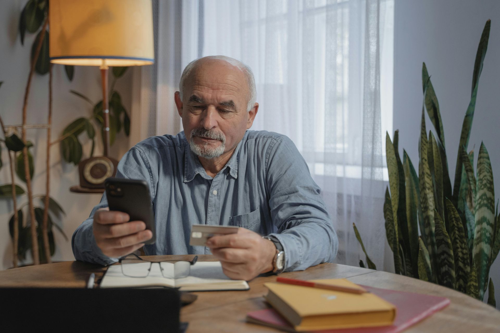 A male pensioner checking his phone while sitting down.