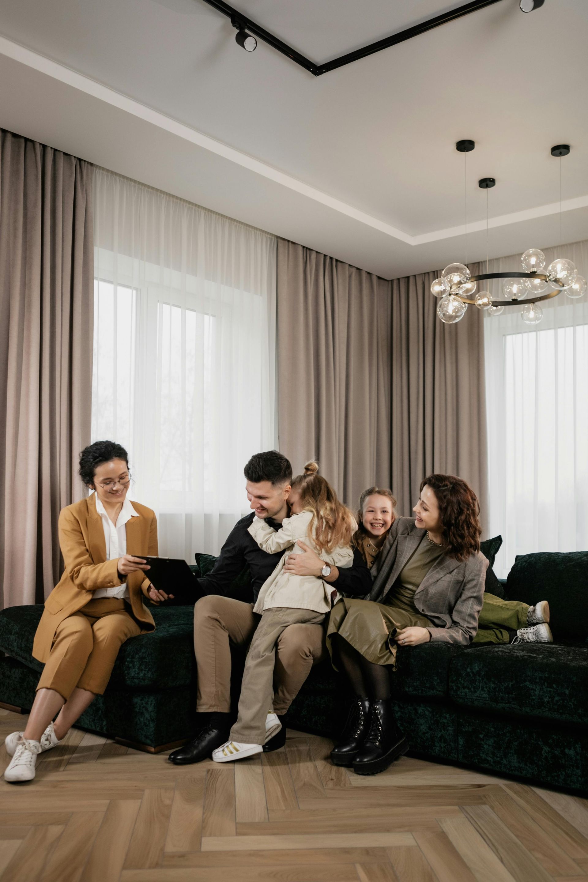 A female broker talking with a family seated on a couch.