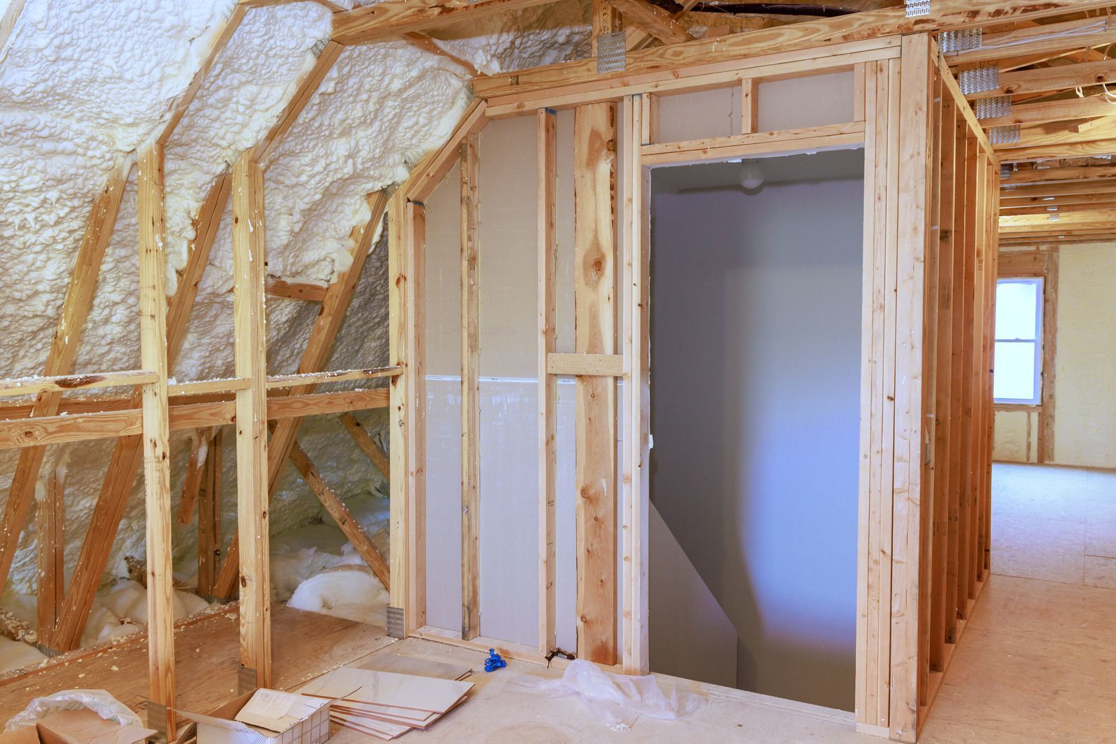 A room in a house under construction with wooden walls and a door.