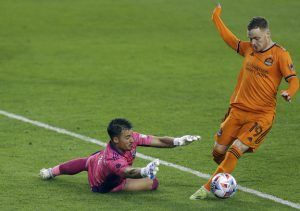 Two soccer players are playing a game of soccer on a field.