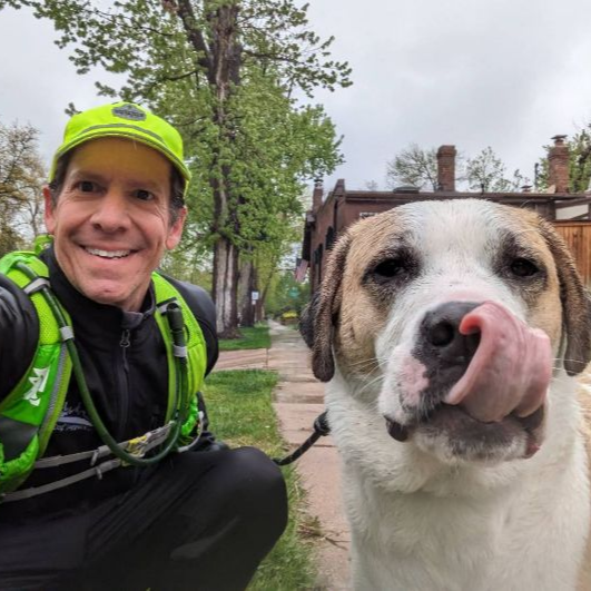 A man is taking a selfie with his dog who is sticking its tongue out