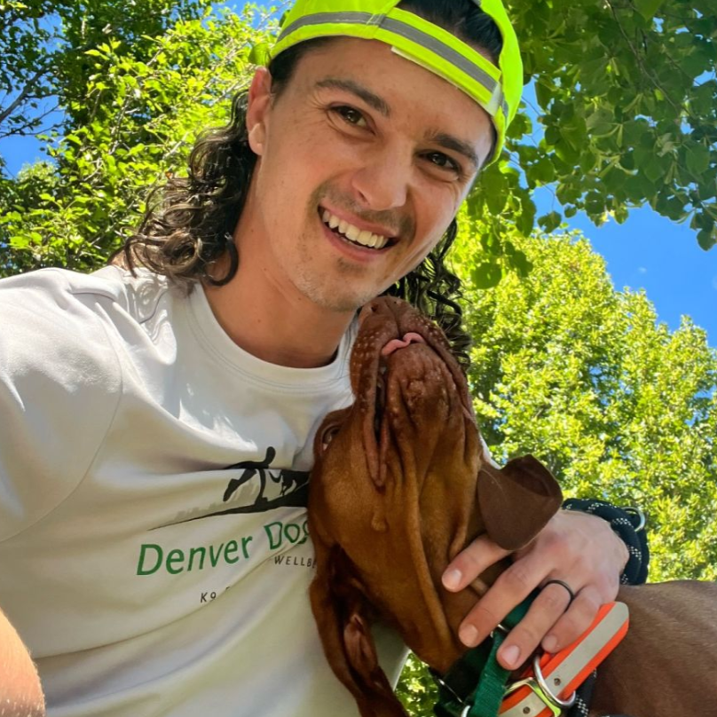 Tyler H wearing a green vest that says Denver Dog Joggers