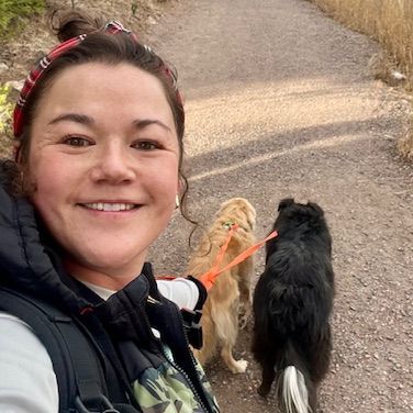 Lisa taking a selfie with a group of dogs