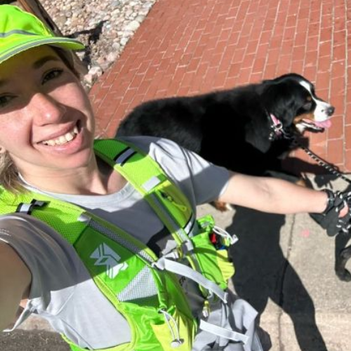 a woman is taking a selfie with her dog on a leash .