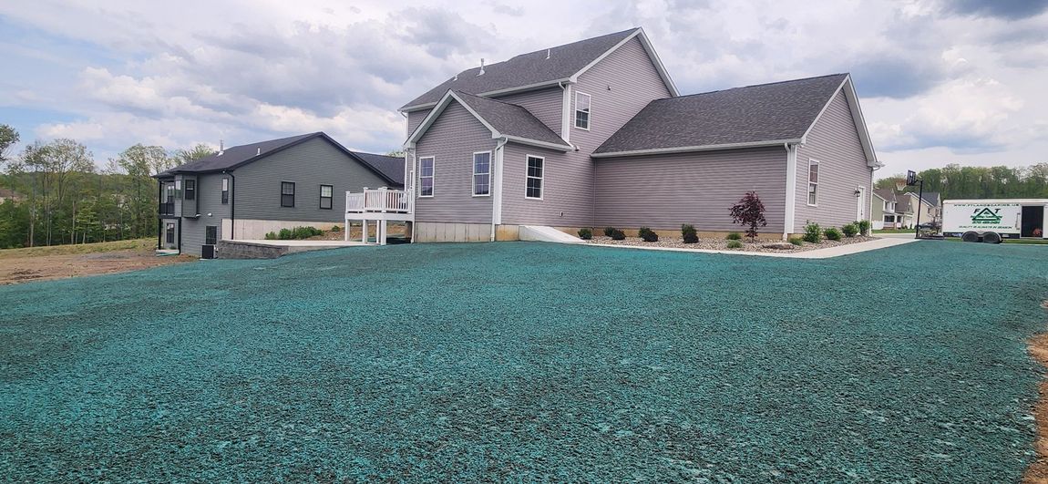 A large house with a lot of green gravel in front of it.