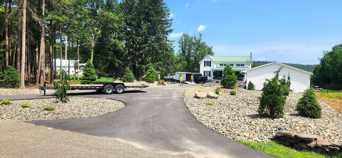 A trailer is parked in a driveway next to a house.