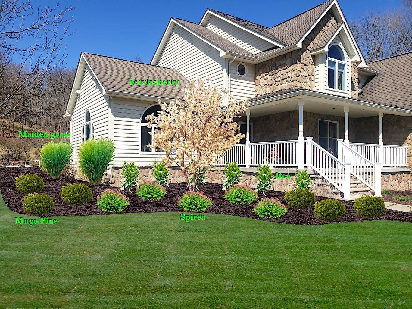 A large white house with a porch and a lush green lawn.