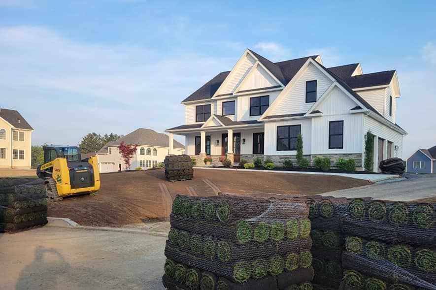 A large white house is being built in a residential neighborhood.