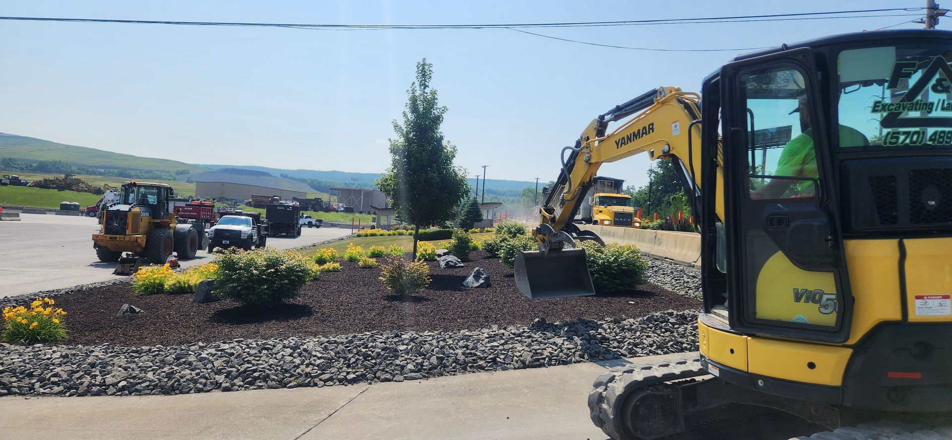 A man is driving a yellow excavator on a construction site.