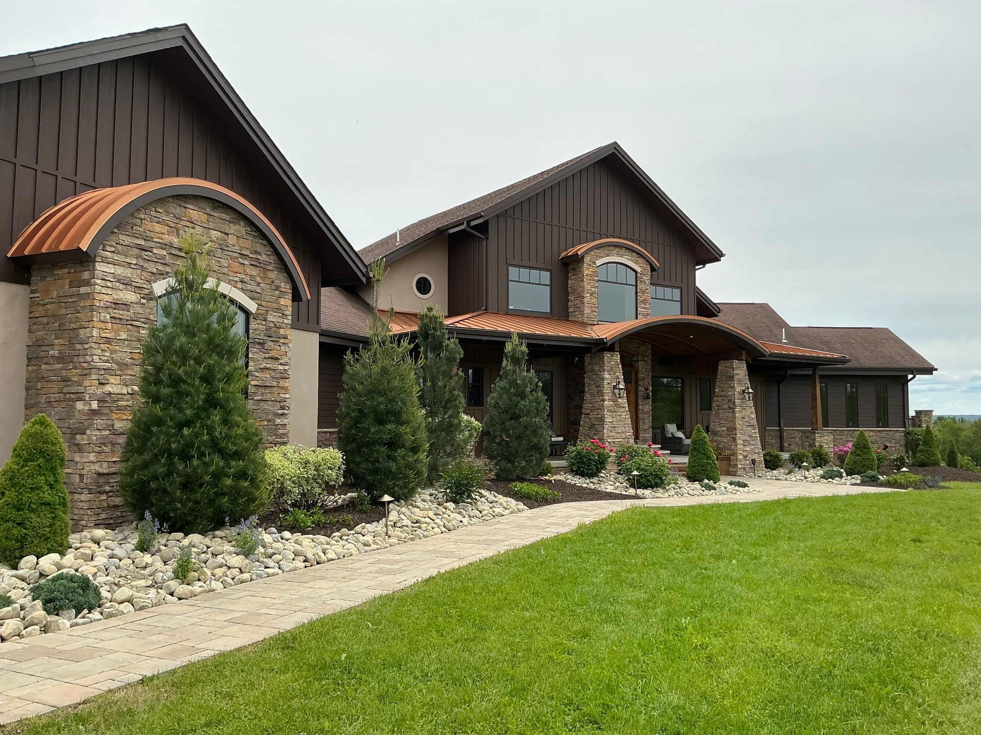 River rock, meticulously placed plants and shrubs, and mulch that adds color to this homes curb appeal.
