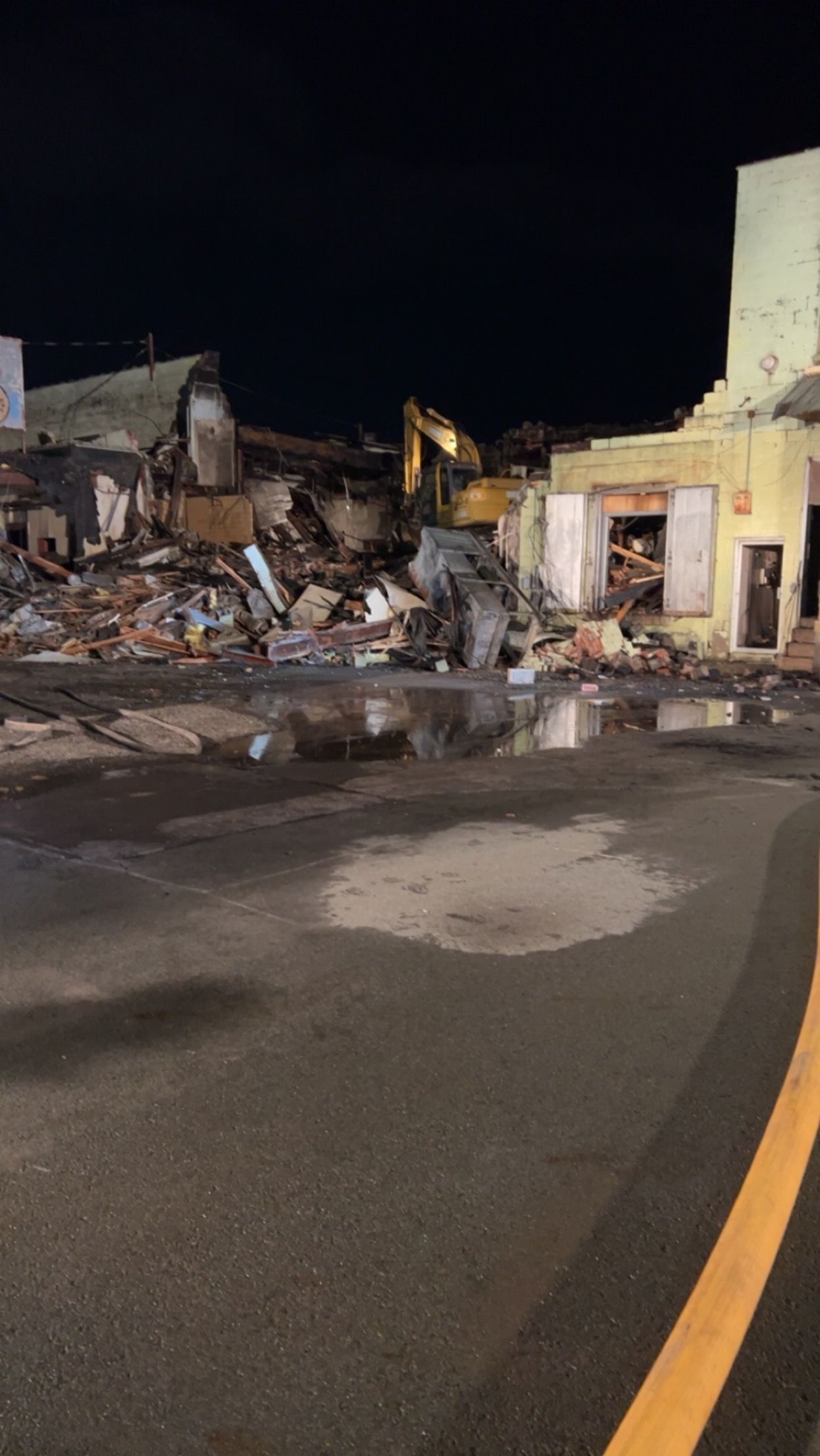 A large building is being demolished at night.