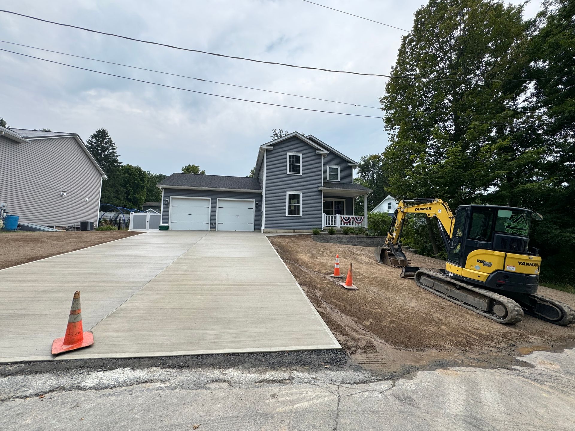 A concrete driveway is being built in front of a house.