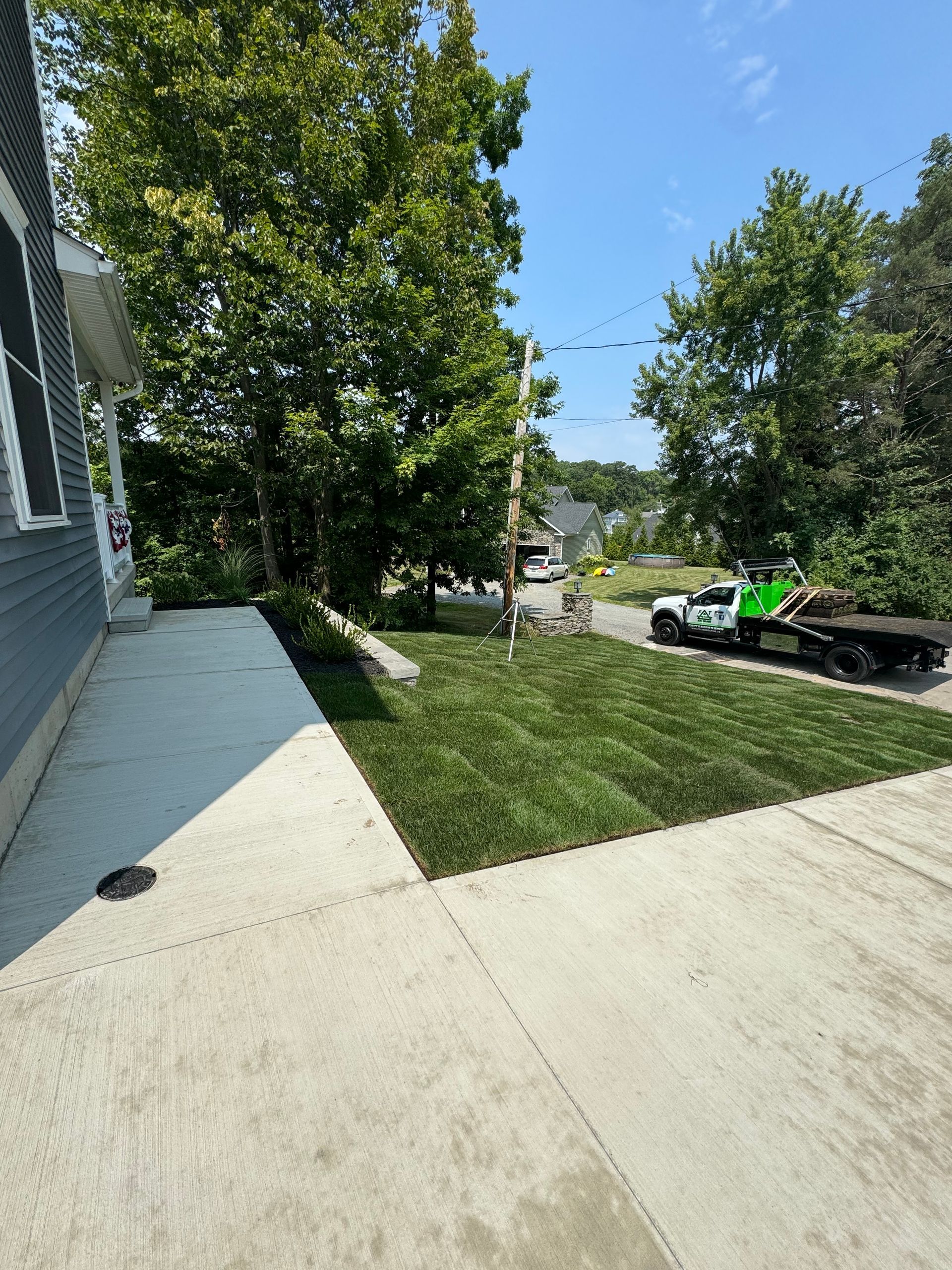 A tow truck is parked in front of a lush green lawn.