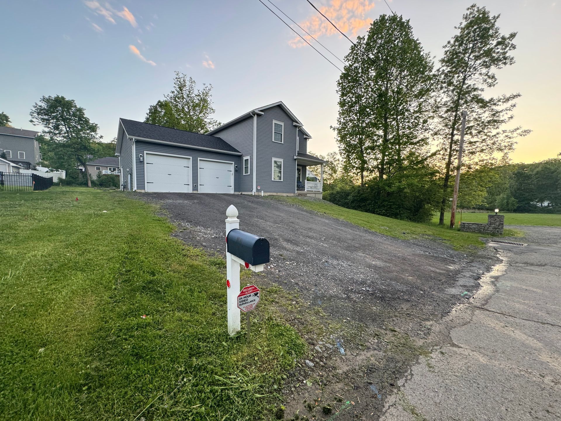 A mailbox is in front of a house with a driveway.