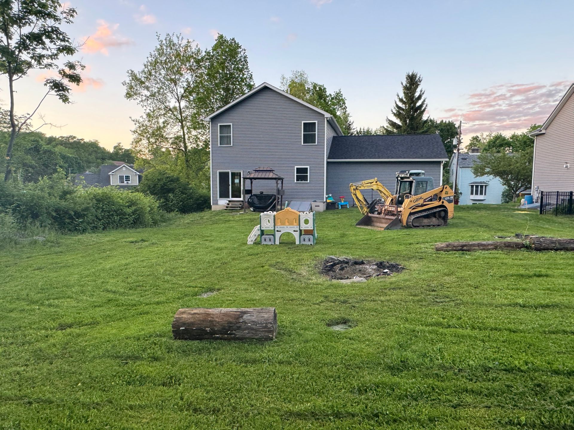 There is a fire pit in the backyard of a house.