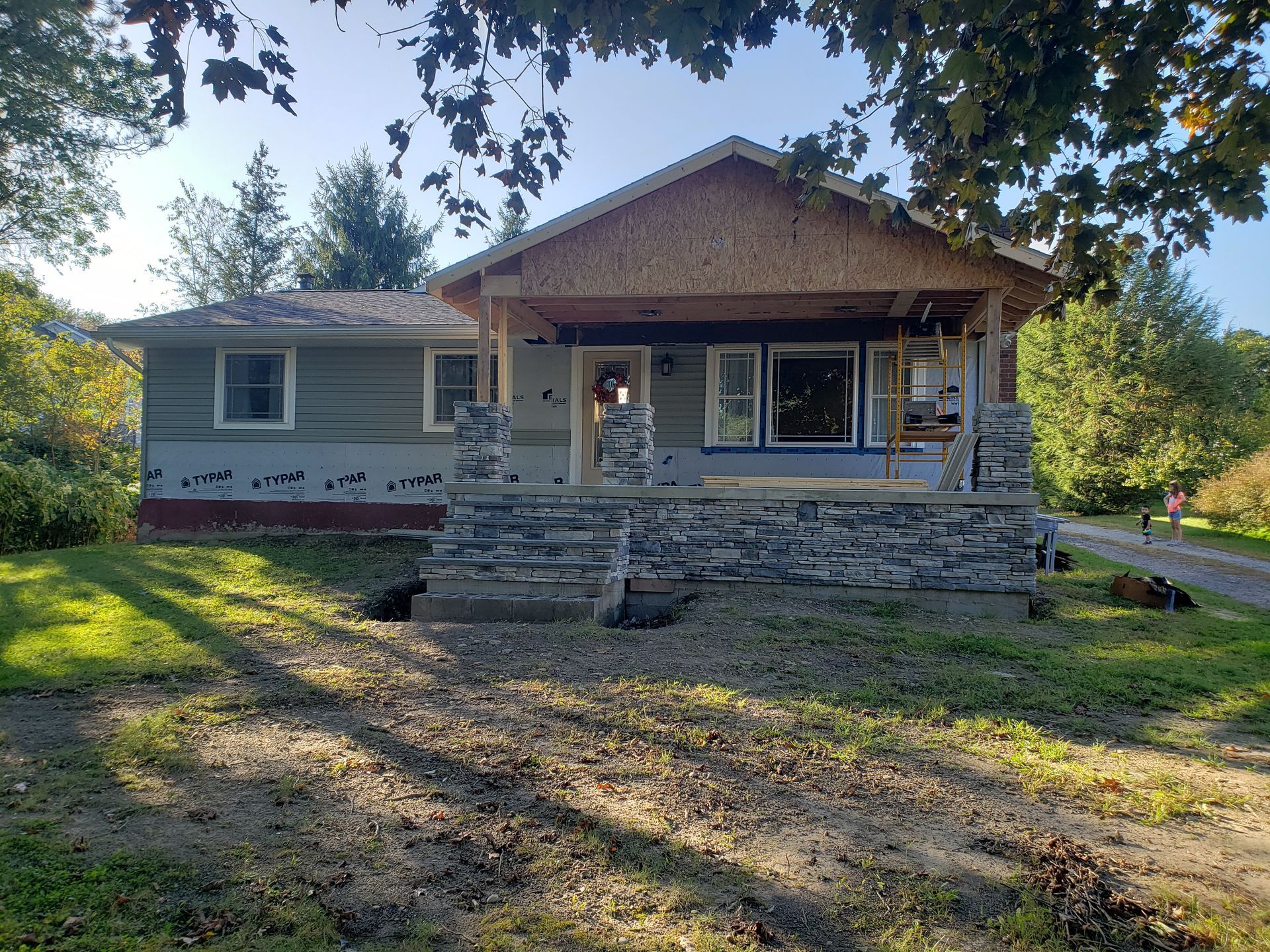 A house is being remodeled with a stone porch and stairs.