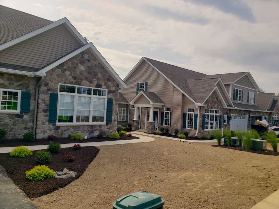 A row of houses with a green trash can in front of them