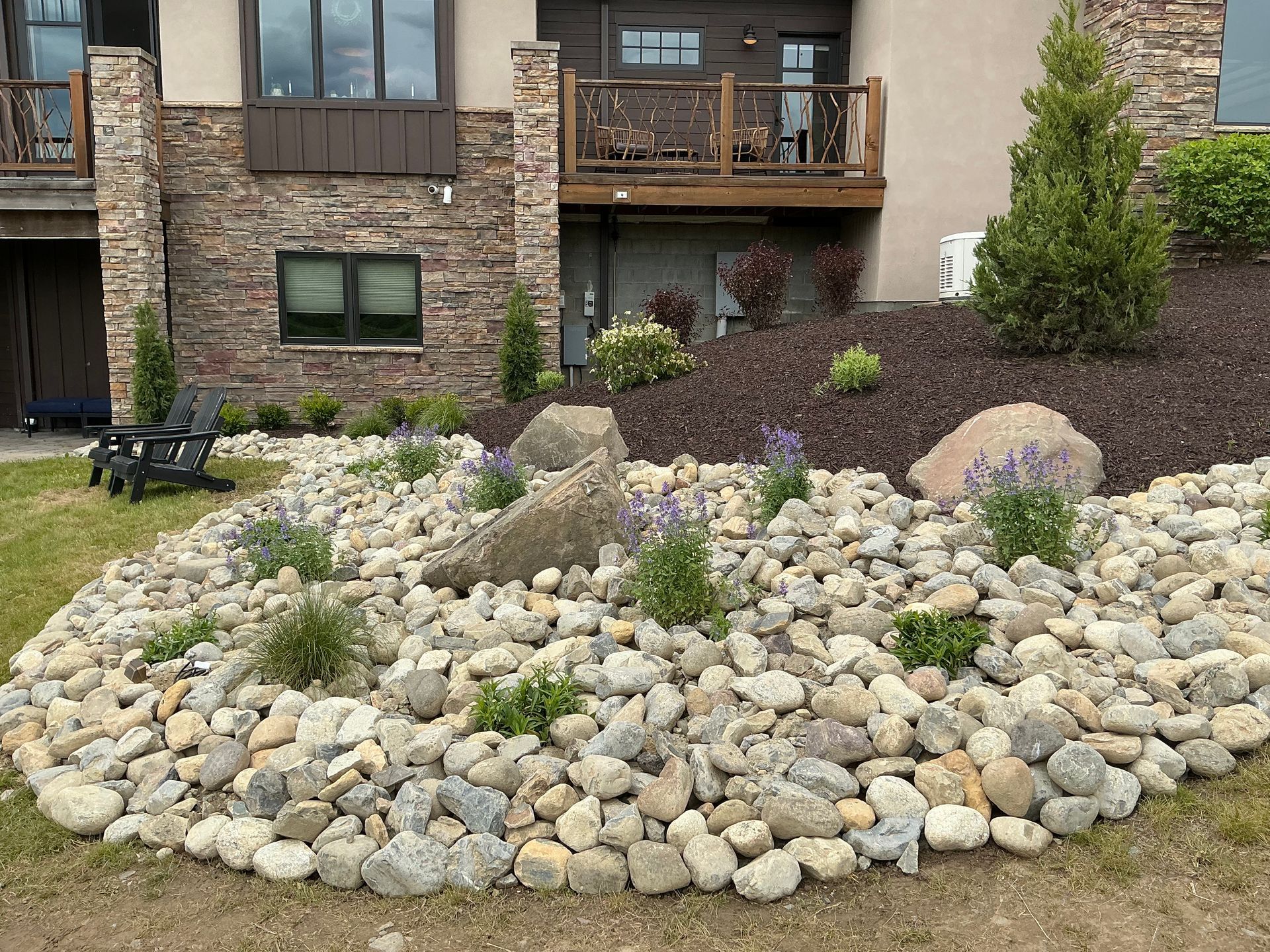 New landscaping to complement the lifestyle and design of this sprawling home. Large bolder rocks, annuals to add a pop of color, fresh mulch and some low maintenance bushes for year long curb appeal