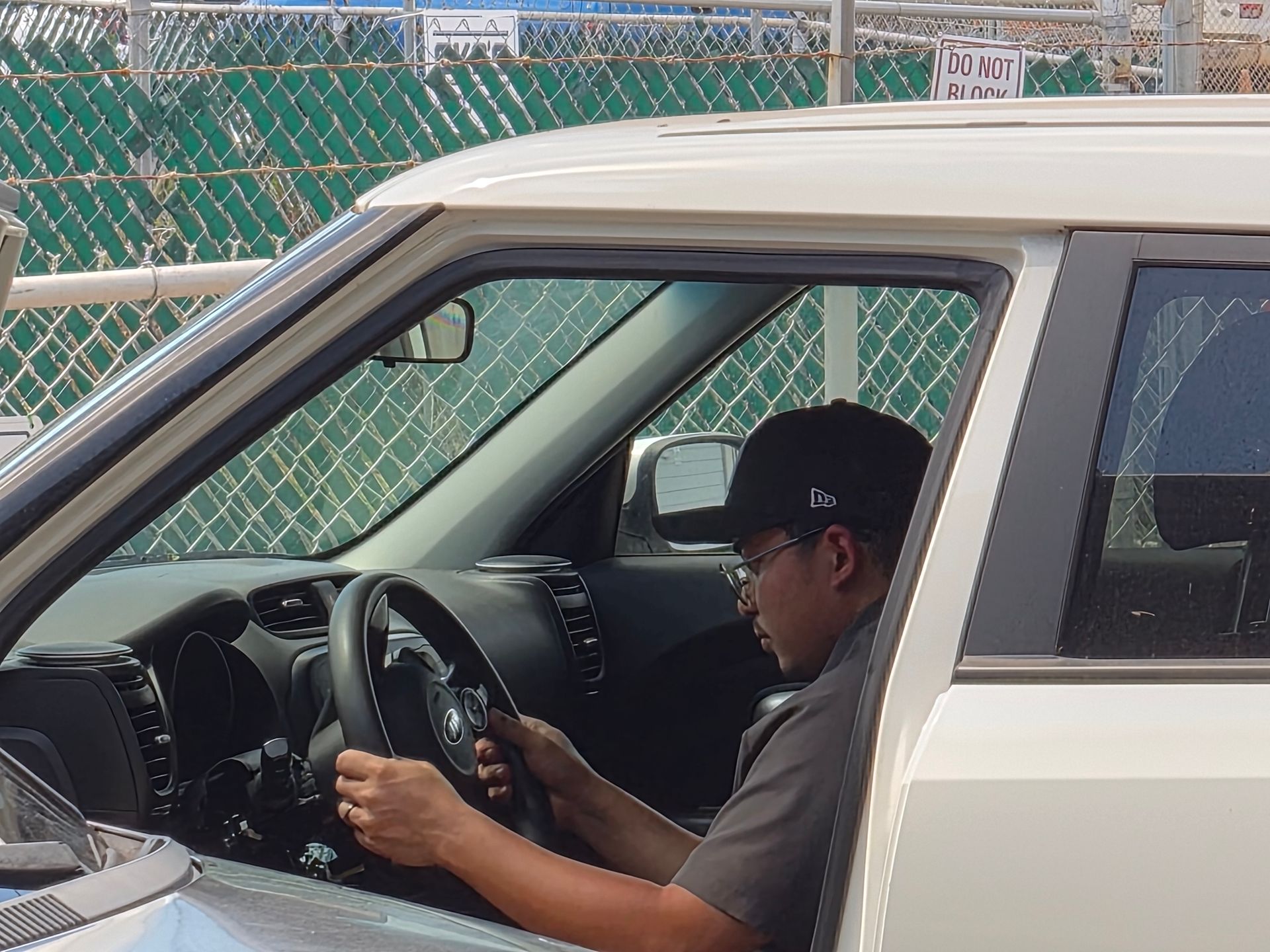 a man is using a tablet in a garage next to a car .