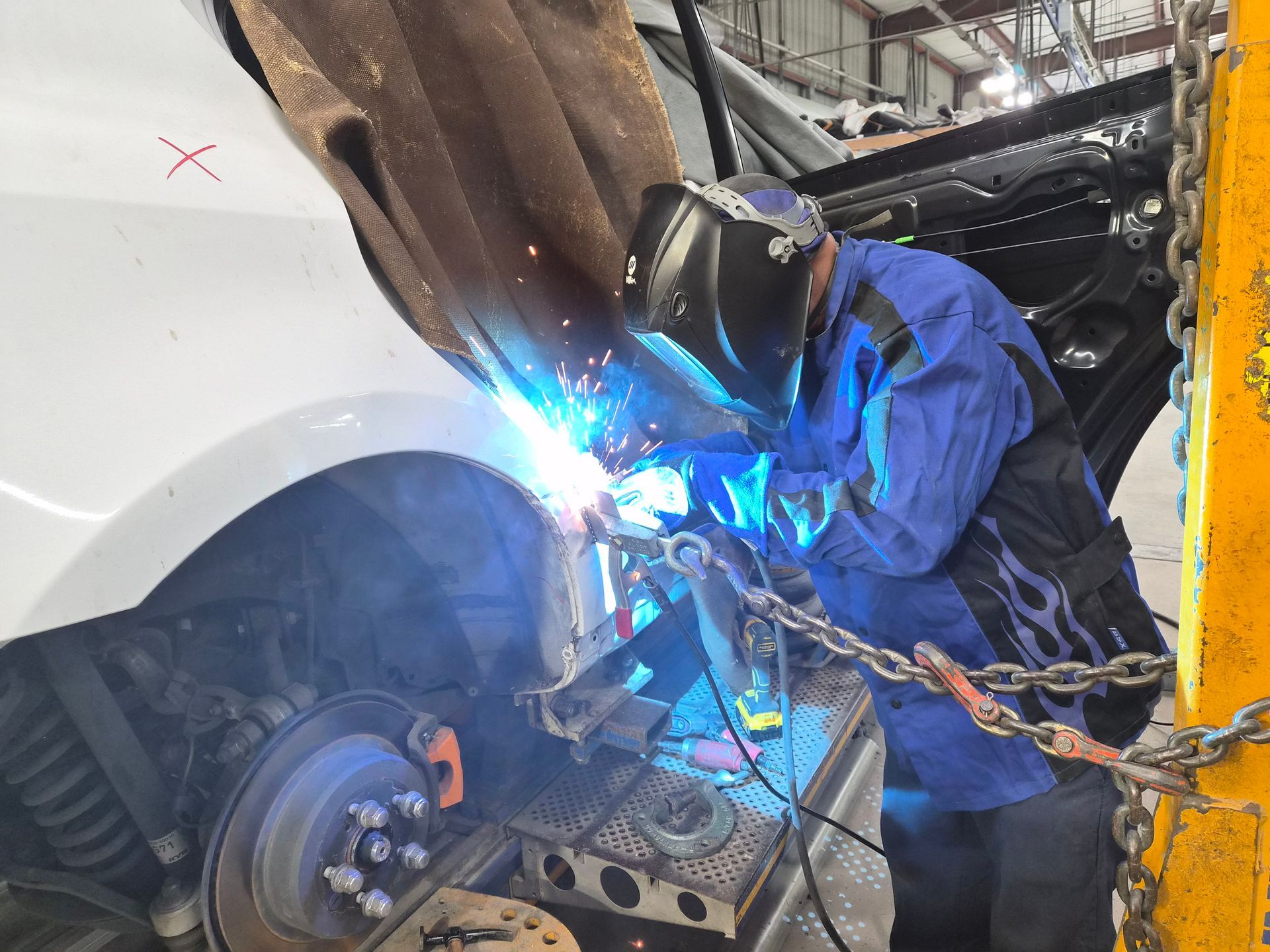 a man is polishing a white car with a machine .