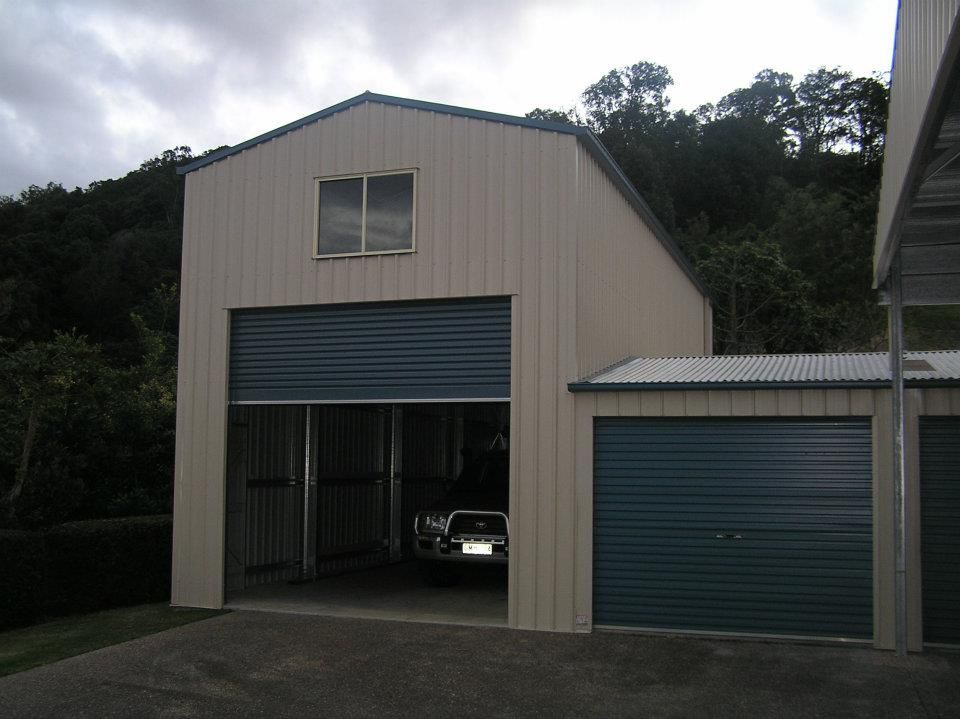A Car Is Parked In A Garage With The Door Open — Austeel Sheds in Bowen, QLD