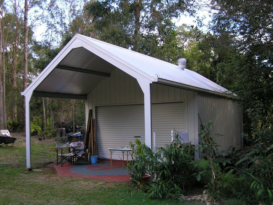 A White Garage With A Canopy Over It — Austeel Sheds in Bowen, QLD