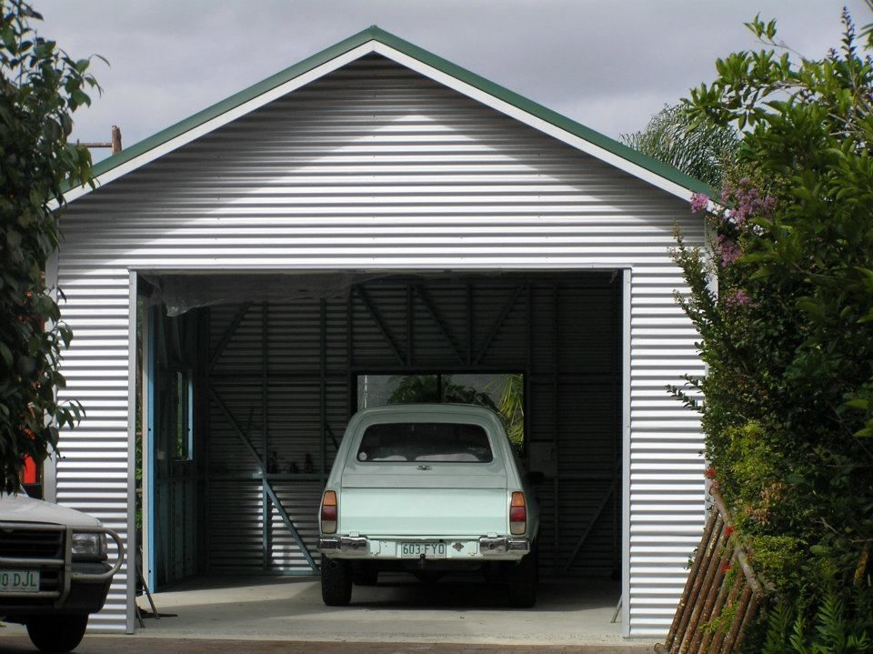 A White Truck Is Parked In A Garage With The Door Open — Austeel Sheds in Collinsville, QLD