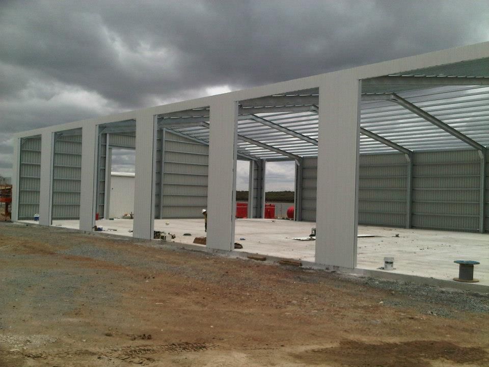 A Building Under Construction With A Cloudy Sky In The Background — Austeel Sheds in Collinsville, QLD