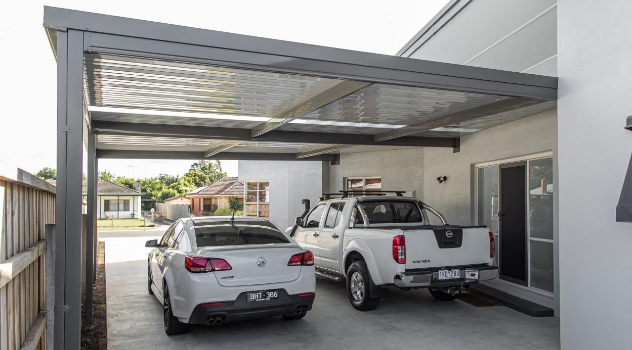 A Brick House With A Covered Patio In Front Of It — Austeel Sheds in Bowen, QLD