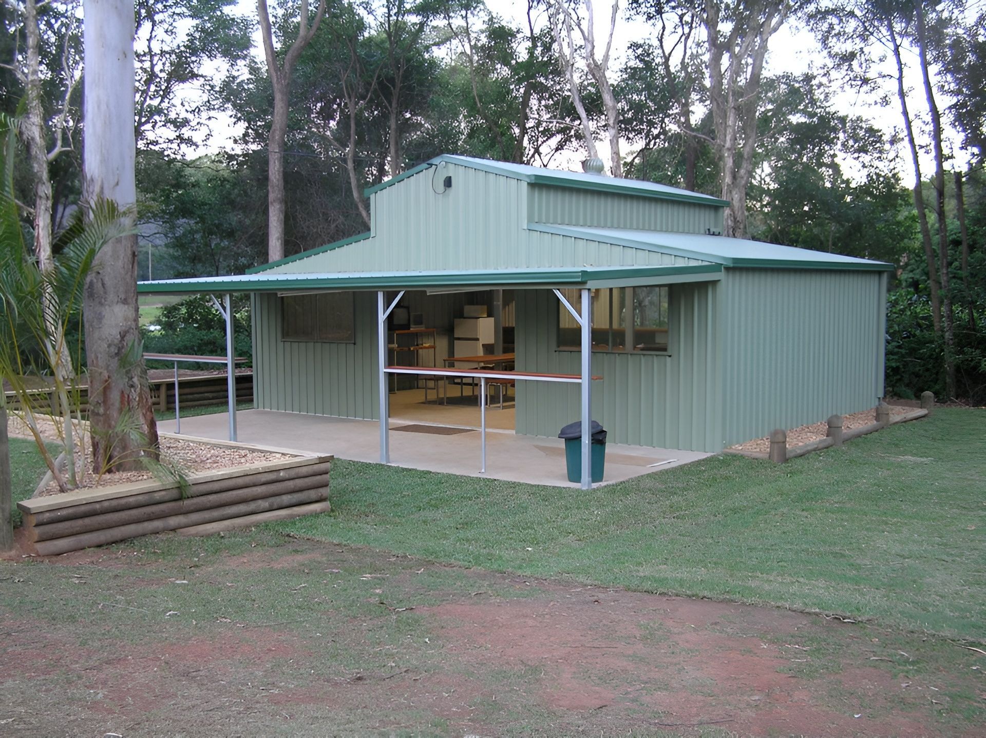 A Brick House With A Covered Patio In Front Of It — Austeel Sheds in Bowen, QLD