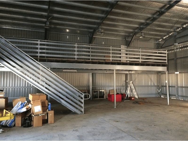 A Warehouse With A Staircase Leading Up To The Second Floor — Austeel Sheds in Bowen, QLD